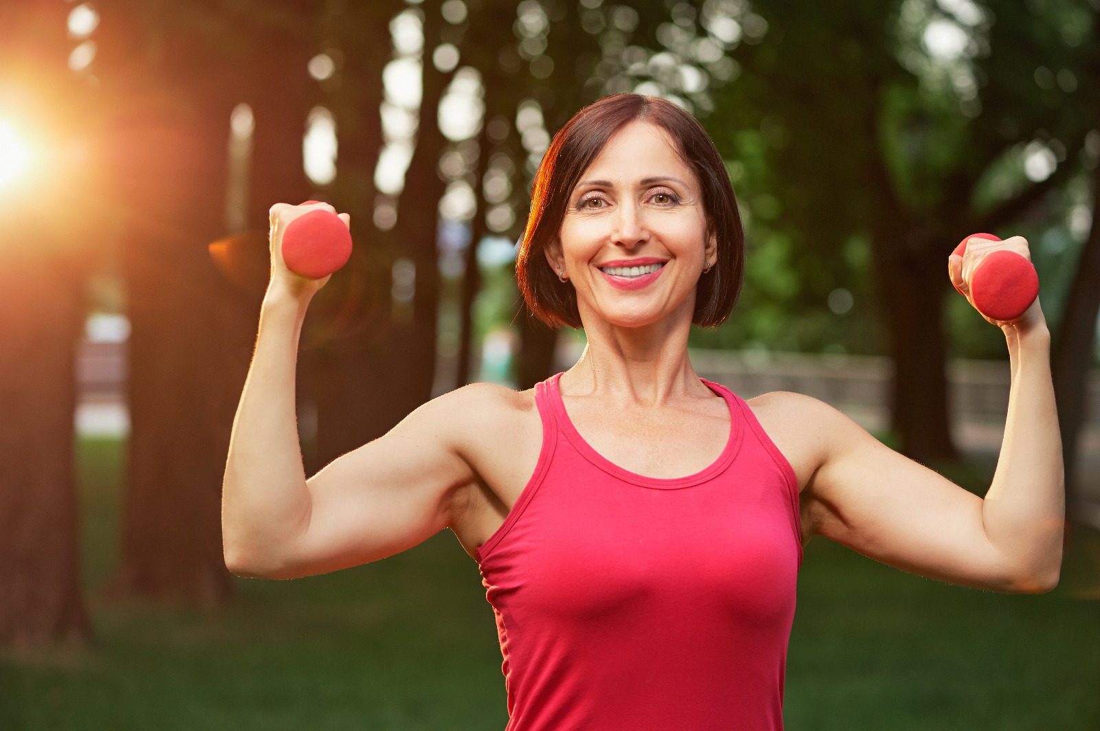 Woman in pink clothes lifting a pink dumbbell